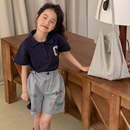 淡いグレーのプリントショートパンツ、前面にメッセージと図柄
