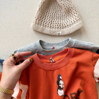 オレンジの長袖Tシャツ、ミッキーマウス風のグラフィックプリント