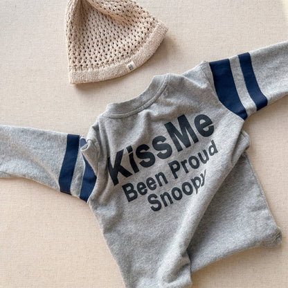 ライトグレーの長袖Tシャツ、ネイビー×白の袖口ラインと「KISS ME」文字