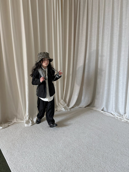 子ども用スーツセット（ジャケット・パンツ）黒。白いインナーが裾からのぞく