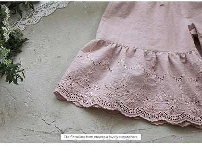 ピンクのレースフリル裾ガウチョパンツ、花柄刺繍風の透かしレース