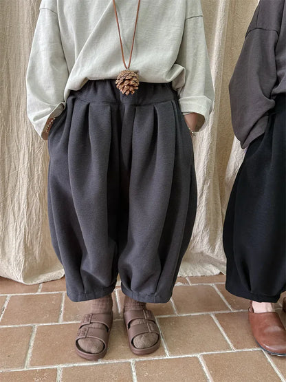 キッズ用ルーズタックパンツ（ダークグレー）。前側タックと丸みのある裾