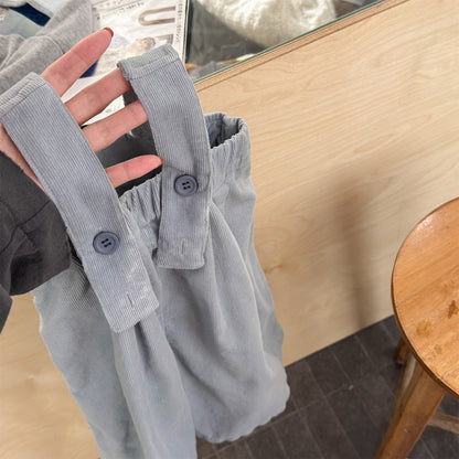淡いブルーのデニムサロペットパンツ、肩ひもボタン留めのアップ