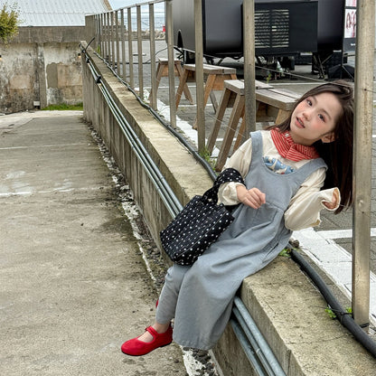 淡いブルーのデニムサロペットパンツ、肩ひも付きのゆったりシルエット