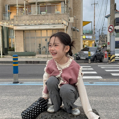 ピンクのVネックニットベスト、前立てボタンとフリル付き