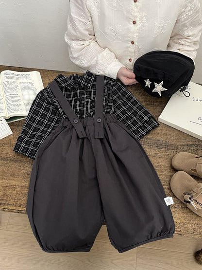 チャコールグレーのサロペットパンツ、フロントボタン留めとふんわり広がるバルーン形