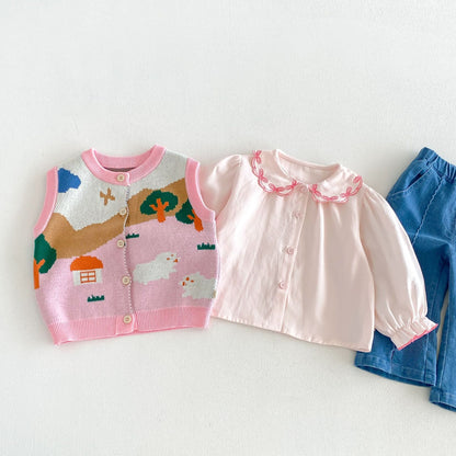 ピンク系のジャガードニットベストと白×ピンクフリル長袖、青デニムパンツ