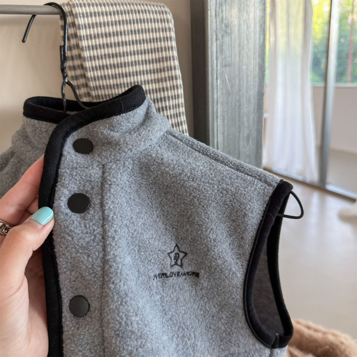 キッズ用グレーのフリースベスト、星刺繍と前ボタンのアップ