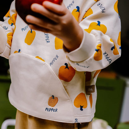 袖と前面ポケットが見える白いスウェット。唐辛子の総柄プリント。