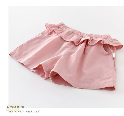 ピンクのハーフパンツ（フリル切替）。サイドにジップ、やわらかい生地