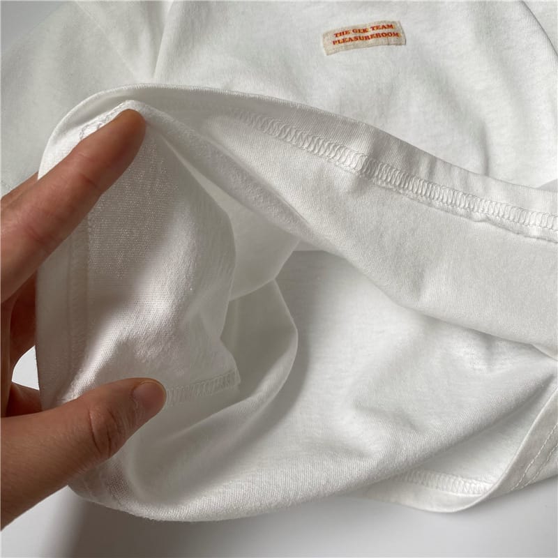 白いキッズ半袖Tシャツの生地アップ、胸のワンポイントプリント付き