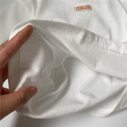 白いキッズ半袖Tシャツの生地アップ、胸のワンポイントプリント付き