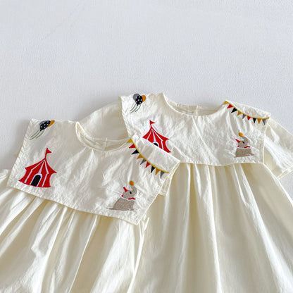 子ども用ホワイトワンピース、総柄の刺繍モチーフ。フリル付きの丸い襟