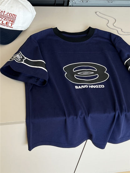 紺のコットンTシャツ、フロントの大きなロゴプリント、黒リブ襟、半袖