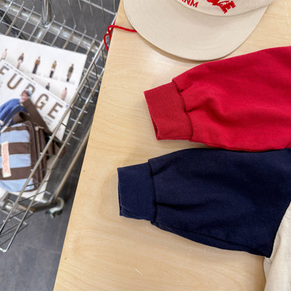 紺色と赤色の長袖Tシャツ、袖口と裾のデザインが見える