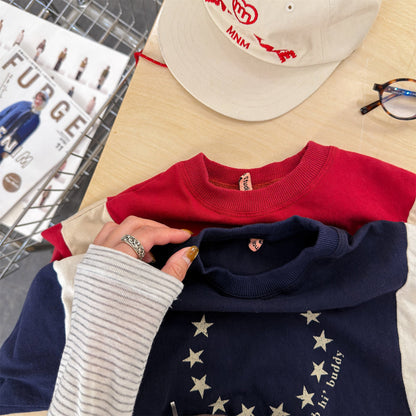 紺色の長袖Tシャツ、星柄プリントとロゴ文字の胸元アップ