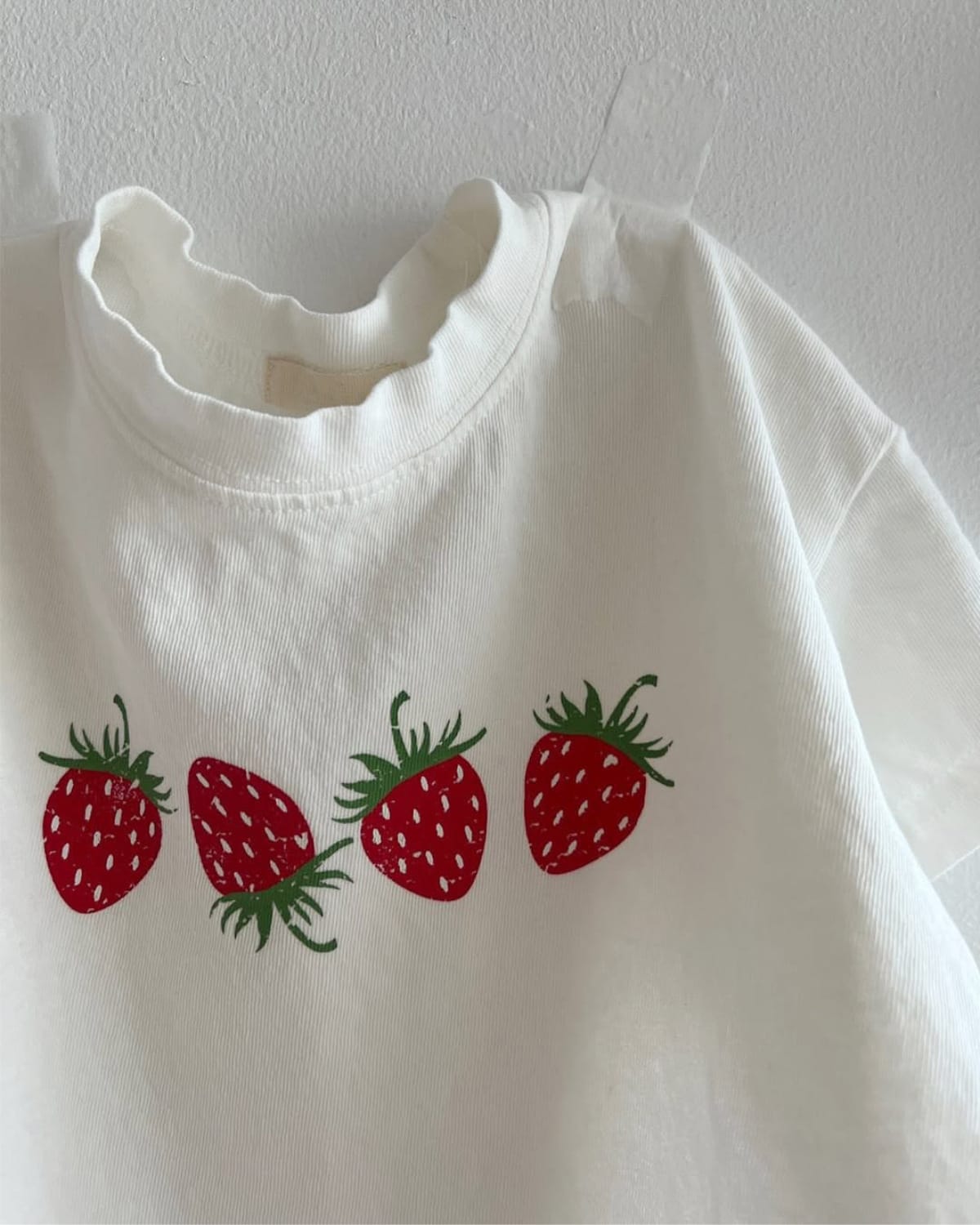 クリームホワイトのいちご柄半袖Tシャツ（胸元アップ）
