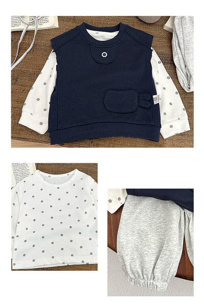 ネイビーのポケット付きベスト風トップスと白のドット柄長袖Tシャツ