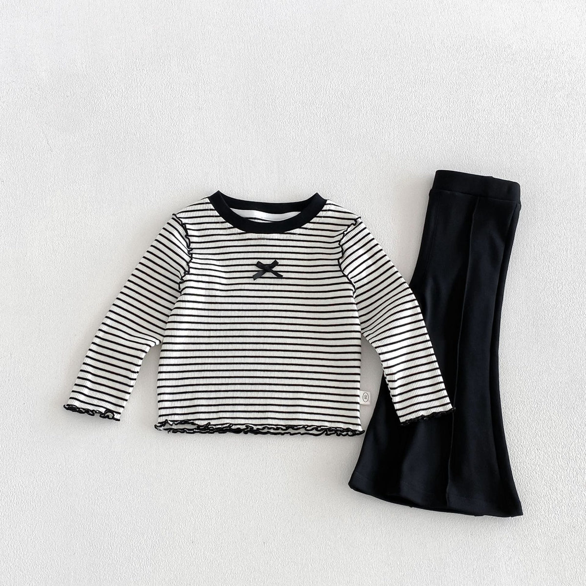 ボーダー柄の長袖Tシャツと黒いフレアパンツ