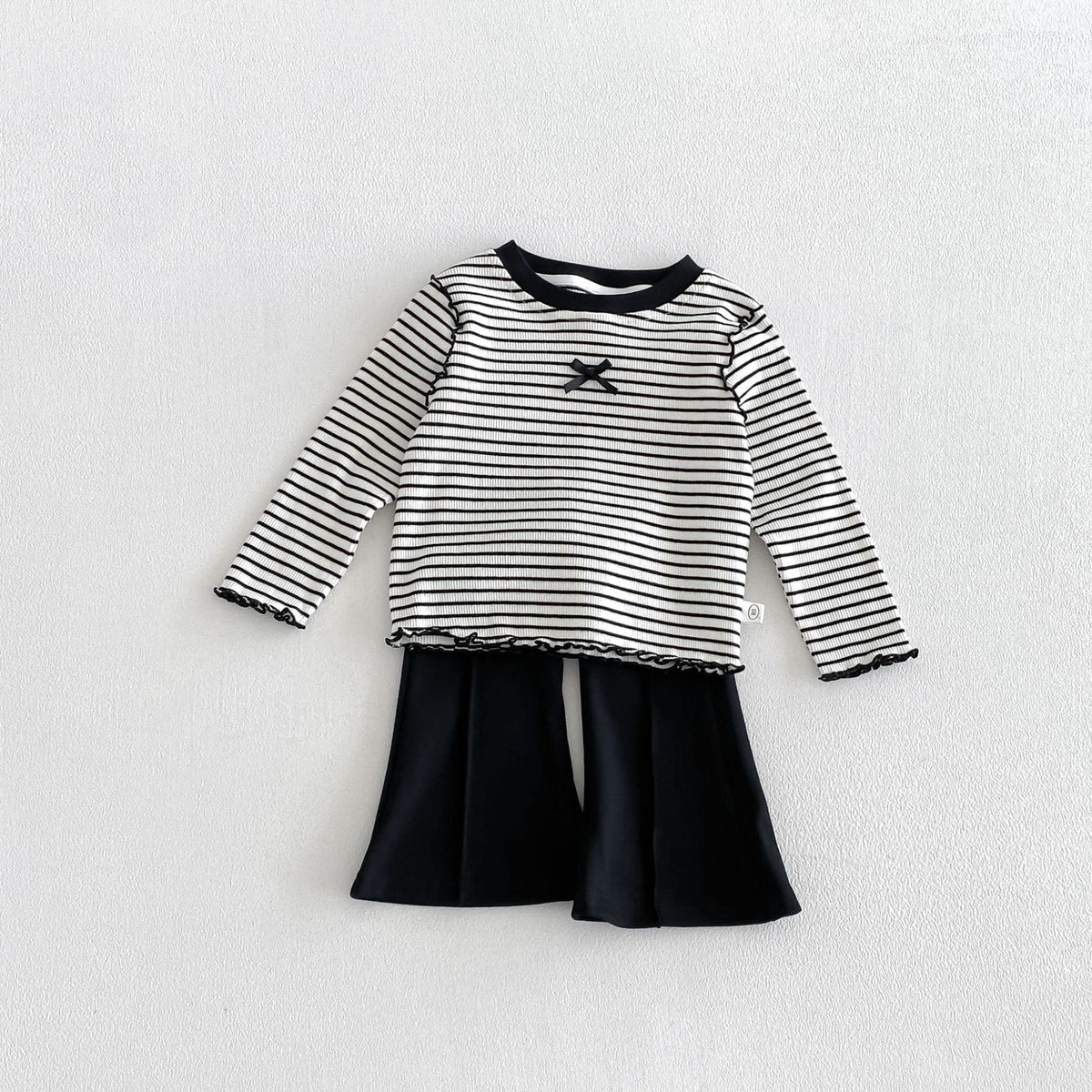 子ども用ボーダー長袖Tシャツ、胸のリボン風モチーフと黒メロー裾、フレアボトム