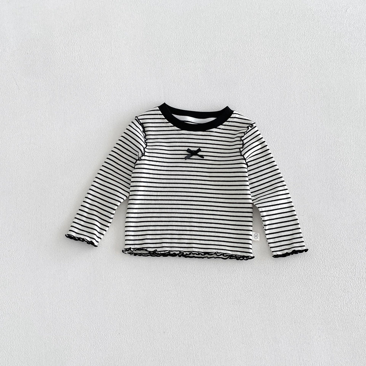 子ども用ボーダー長袖Tシャツ、黒リブ首元とメロー裾、胸のリボン風モチーフ