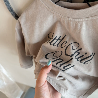ベージュのキッズ長袖Tシャツ、胸元に英字ロゴプリント