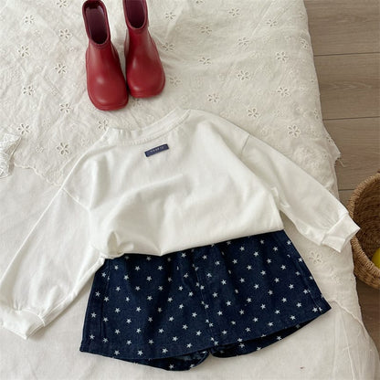 キッズ用ルーズ長袖Tシャツ、ホワイト地に胸の小さなタグ、ゆったりシルエット